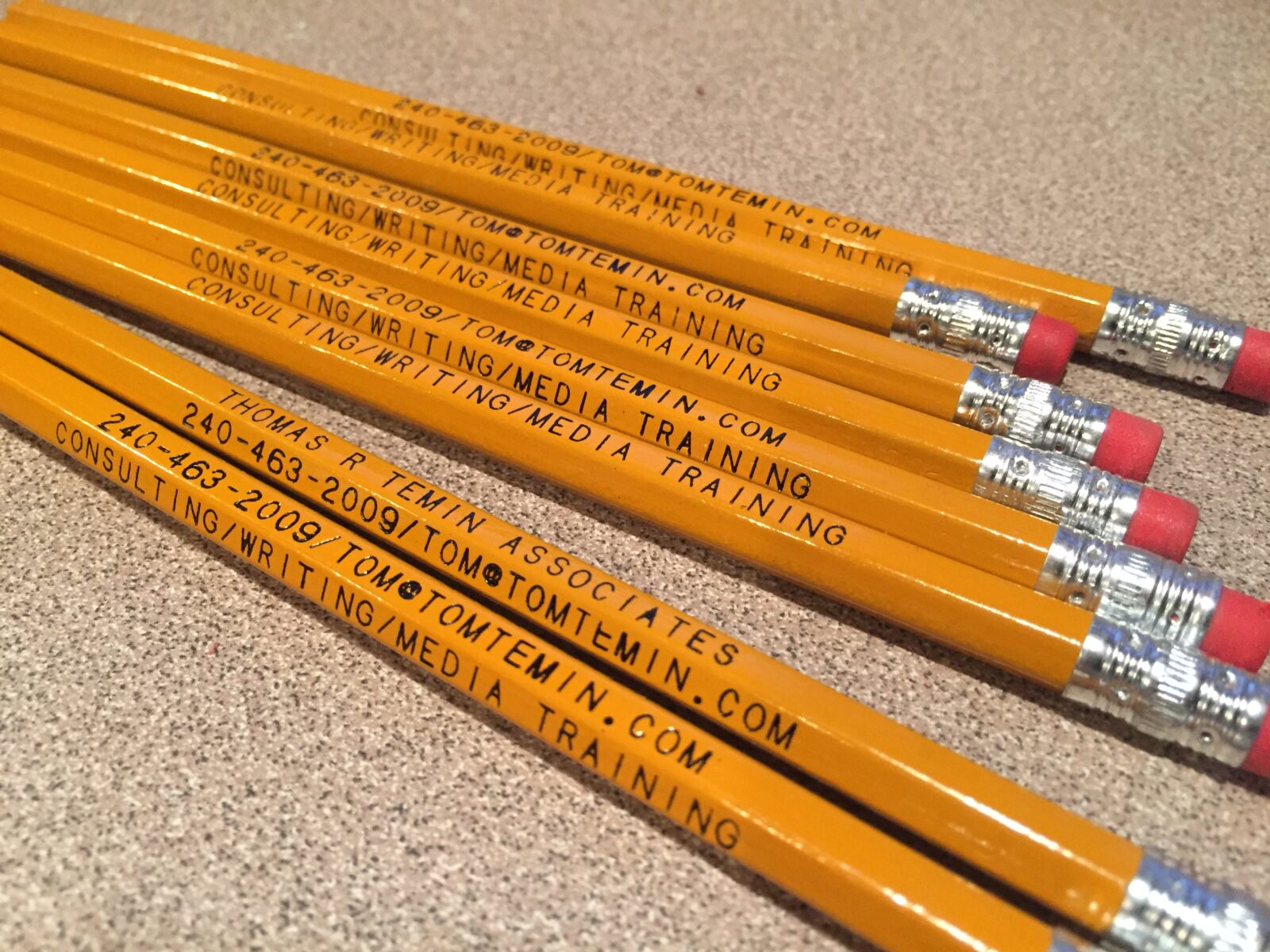 Yellow pencils with printed contact information.