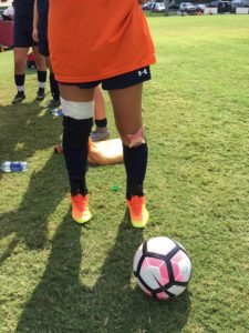 Soccer player with ball on grassy field.