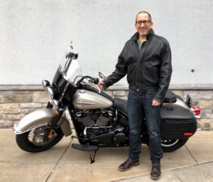 Man standing next to a motorcycle.