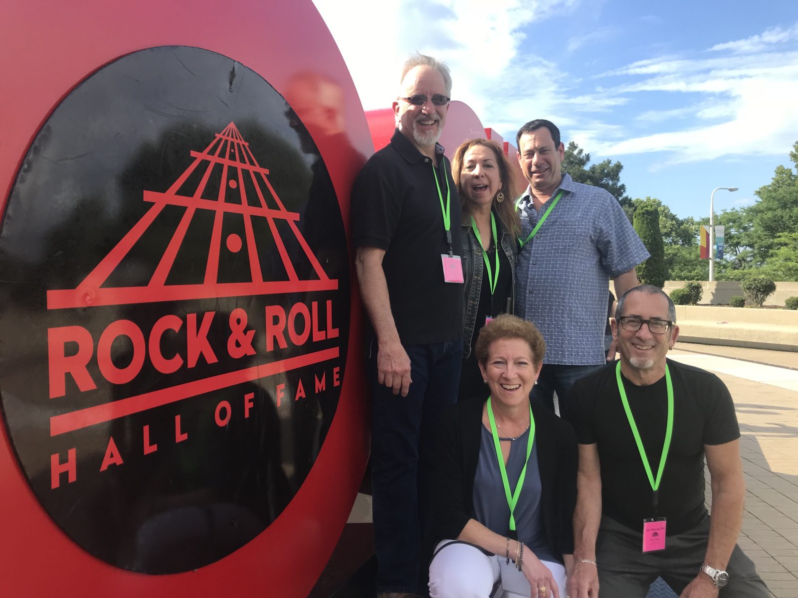 A group of people standing in front of rock and roll hall of fame.