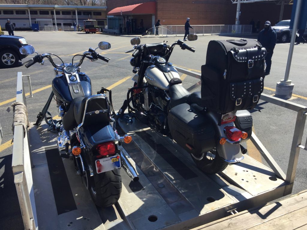 Two motorcycles secured on a trailer.