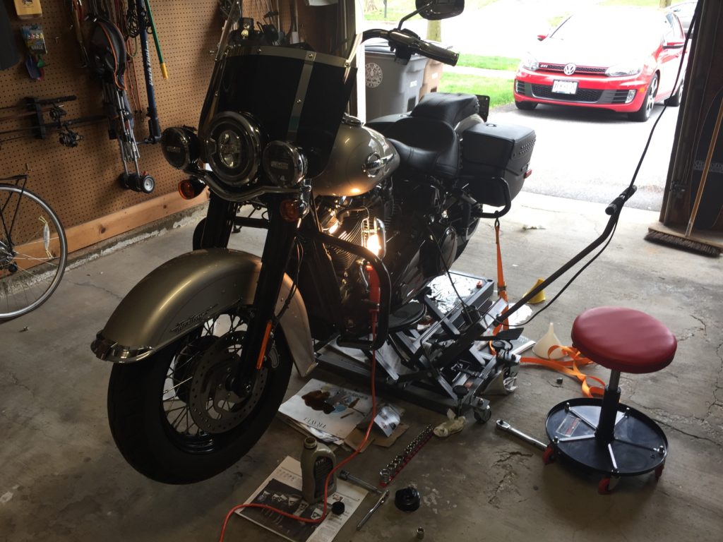 Motorcycle undergoing maintenance in a garage.