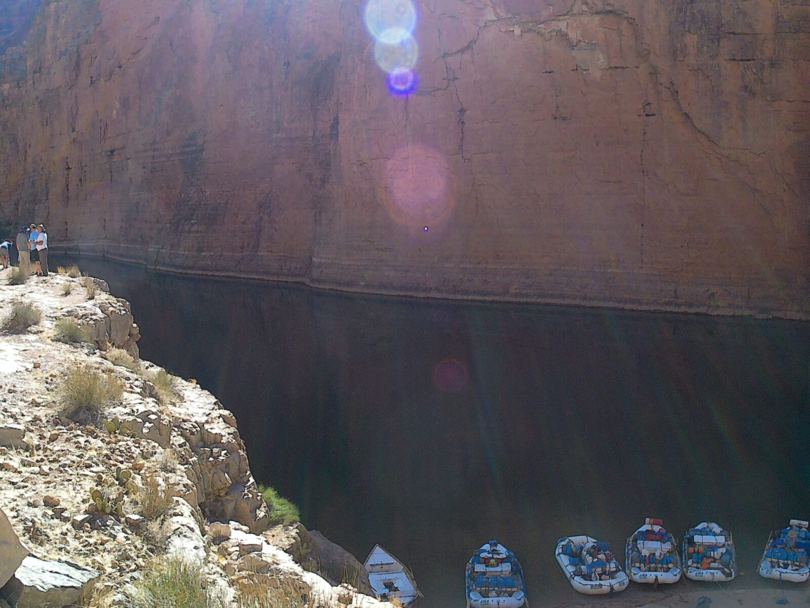 Boats docked by steep rocky canyon walls.